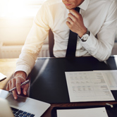 Businessman working on laptop with documents